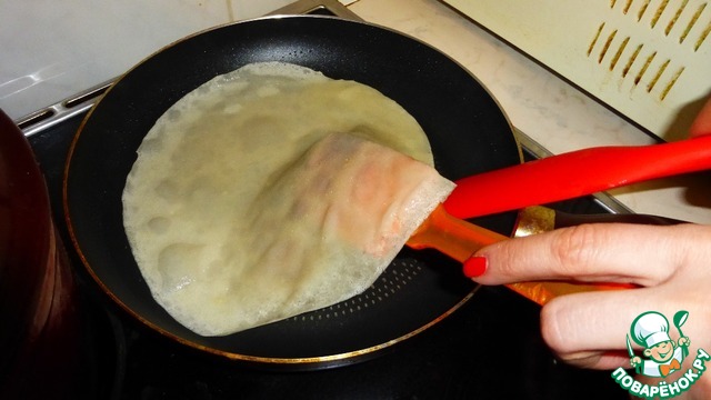 переворачивание блинчиков. сковорода для приготовления блинов. переворачивает блин на сковороде.
